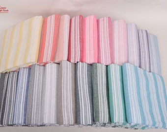 May include: A collection of folded striped towels in various colors, including yellow, pink, blue, and gray. The towels have a classic striped pattern and are neatly stacked, showcasing a range of hues and textures. The towels are suitable for bathroom or beach use.