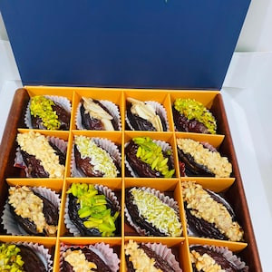 May include: A white ceramic mug with a black handle and the text "But First, Coffee" in a bold, black font. The mug is set against a blurred background, suggesting a cozy setting. The mug appears to be approximately 4 inches tall.