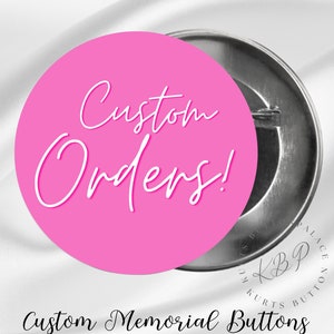 May include: A pink button with the text "Custom Orders!" in white cursive writing. The button is attached to a silver pin back. The text "Custom Memorial Buttons" is written in black below the button.