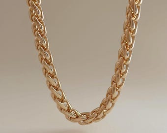 May include: A gold-colored chain necklace with a thick, braided design. The necklace is displayed against a neutral background. The text "Ready to ship" is visible in the lower left corner.