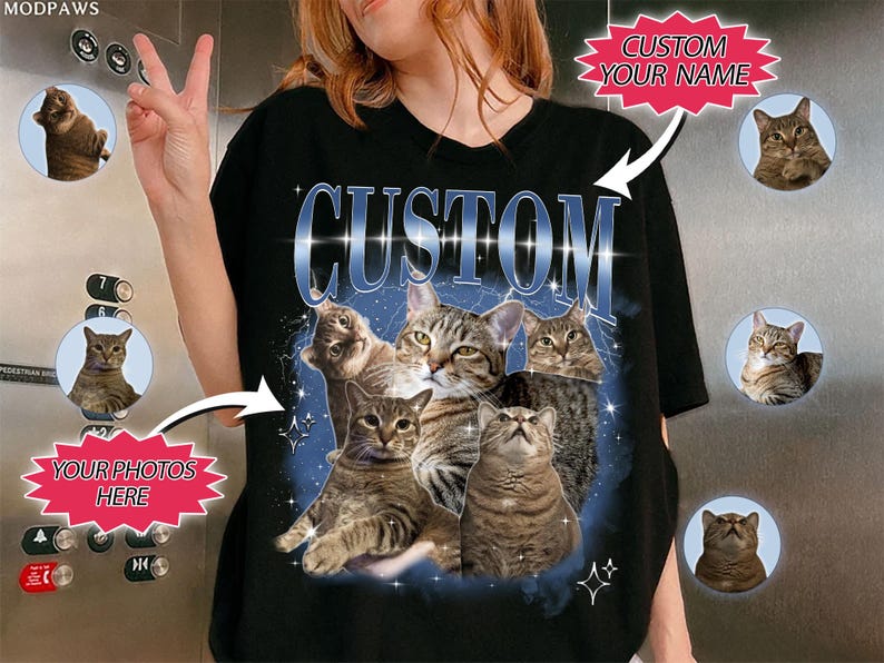 May include: Black t-shirt with a blue and white graphic of cats in a galaxy print. The text "CUSTOM" is printed in blue on the shirt. The shirt is customizable with your own photos of cats.