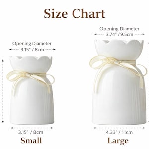 May include: Two white ceramic vases with scalloped openings and ribbon accents. The smaller vase is 5.7 inches (14.5cm) tall with a 3.15 inch (8cm) opening. The larger vase is 7.9 inches (20cm) tall with a 3.74 inch (9.5cm) opening. The image includes a size chart.