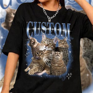 May include: Black t-shirt with a graphic of multiple cats in a vintage style with the word "CUSTOM" in large blue letters.