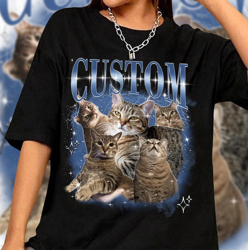 May include: Black t-shirt with a graphic of multiple cats in a vintage style with the word "CUSTOM" in large blue letters.