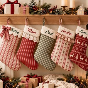 Könnte beinhalten: Fünf personalisierte Weihnachtsstrümpfe hängen in einer Reihe. Die Strümpfe weisen verschiedene Muster auf, darunter rot-weiße Streifen, grün-weißes Vichy-Karo und einen roten Stoff mit weißen Rentier- und Schneeflockenmotiven, jeweils mit Namen.
