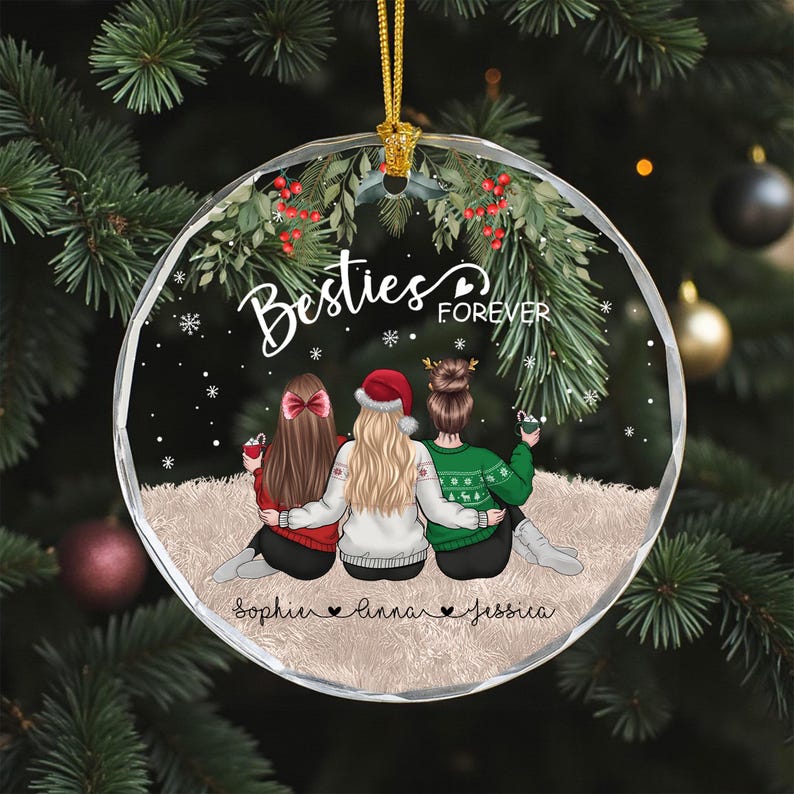 Pu&ograve; includere: Una palla di Natale rotonda e trasparente con un filo d'oro. L'ornamento presenta tre figure con il testo "Besties Forever" e i nomi "Sophie, Linna, Jessica". Le figure indossano maglioni e un cappello da Babbo Natale.