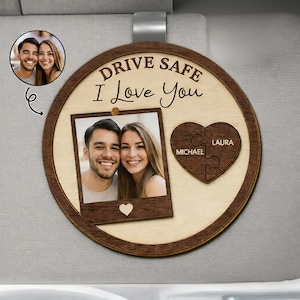 Peut inclure: Un accessoire de voiture en bois de forme circulaire. Il présente une photo d'un couple, les mots "Drive Safe I Love You", et un puzzle en forme de cœur avec des noms. Conçu pour être accroché au rétroviseur d'une voiture.