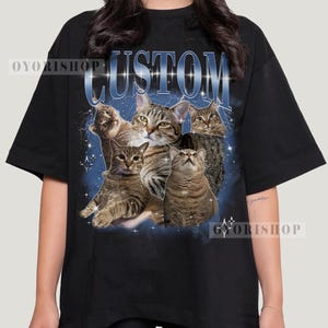 May include: Black t-shirt with a graphic print of five cats in a galaxy-like background. The text "CUSTOM" is printed in white on the shirt.