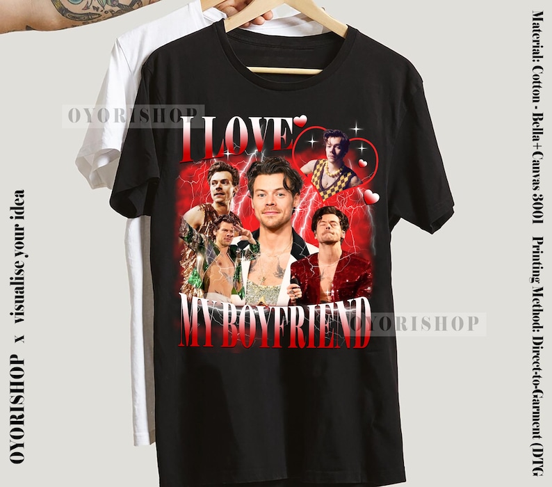 Op de afbeelding: Zwart T-shirt met een grafische print van een groep mannen met de tekst "I LOVE MY BOYFRIEND" in witte letters.