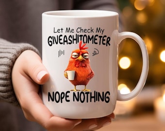 May include: White ceramic coffee mug with a black and white illustration of a chicken holding a cup. The mug has the text "Let Me Check My Giveashitometer Nope Nothing" printed on it.