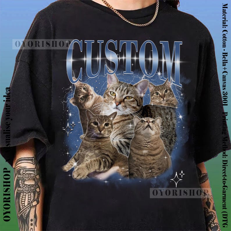 May include: A black t-shirt with a graphic design of five cats in a galaxy-like background. The text "CUSTOM" is printed in white above the cats.