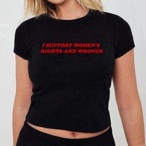 May include: Black crop top with the red text "I SUPPORT WOMEN'S RIGHTS AND WRONGS". The shirt has a crew neck and short sleeves. The fabric appears to be a soft, stretchy material.
