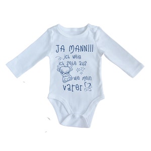May include: White long-sleeve baby onesie with blue text that reads "JA MANN!! ich weiß ich sehe aus wie mein vater". The text is accompanied by a small cartoon cow and stars.