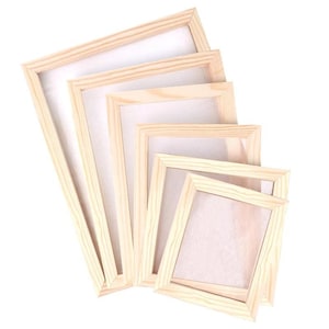 May include: A collection of five wooden artist canvas frames of varying sizes, arranged in a diagonal pattern. The frames are made of light-colored wood and have a white canvas stretched across them. The frames are empty and ready for painting.