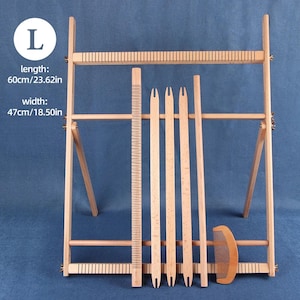 Può includere: Un telaio in legno chiaro, lungo 60 cm e largo 47 cm. Include un pettine, un righello e vari strumenti per la tessitura. Il testo indica: lunghezza: 60 cm/23,62 pollici, larghezza: 47 cm/18,50 pollici.