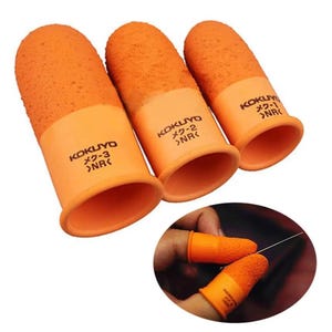 Puede incluir: Tres dediles de goma naranja con superficies texturizadas para mejorar el agarre. Cada pieza tiene impreso el nombre de la marca KOKUYO, un número de modelo y el texto >NR<. Estos dediles están diseñados para colocarse en las yemas de los dedos.