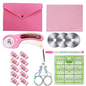 May include: A pink rotary cutter with a 45mm blade, three replacement blades, a pink storage pouch, a pink cutting mat, ten pink sewing clips, a pair of iridescent scissors, and a white Chako Ace Pen with a green square quilting ruler.