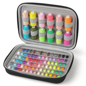 May include: A black zippered sewing kit, open to reveal spools of thread in various colors, including pink, yellow, and blue. The kit also contains a variety of thread bobbins in a wide array of colors, neatly organized for easy access.