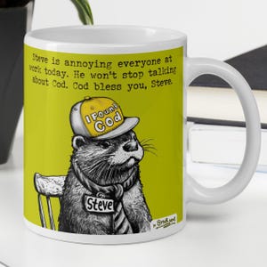May include: White ceramic mug featuring a cartoon otter wearing a hat that says "I Found God." The otter is wearing a tie and a name tag that says "Steve." The mug has text that reads "Steve is annoying everyone at work today."