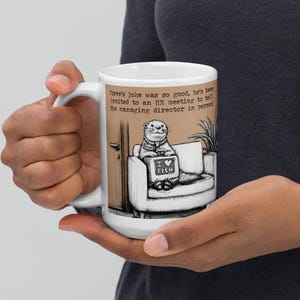 May include: White ceramic mug featuring a cartoon otter sitting on a couch, holding a sign that says "I love fish." The mug has text that reads "Steve's joke was so good, he's been invited to an HR meeting to tell the managing director in person."