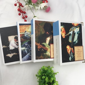 May include: Four hardback books with distinctive cover art. The covers display paintings of a person playing a guitar, a person playing a violin, a person sitting, and a pigeon. The book spines are blue with white text. The books are titled "The Cadence of Part-Time Poets."