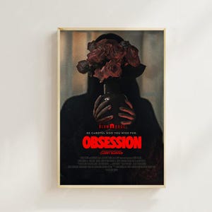 Puede incluir: Póster de película enmarcado para "Obsession" con un tema oscuro. Una figura sostiene un jarrón de rosas rojas, ocultando su rostro. El título es rojo, con el lema: "Ten cuidado con lo que deseas." El marco es de madera.