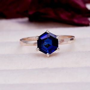 Könnte beinhalten: Ein Set aus drei Keramikbechern mit gesprenkelter, matter Oberfläche. Die Becher sind in Creme-, Hellgrau- und Dunkelgrautönen gehalten. Jeder Becher hat ein schlichtes, minimalistisches Design.