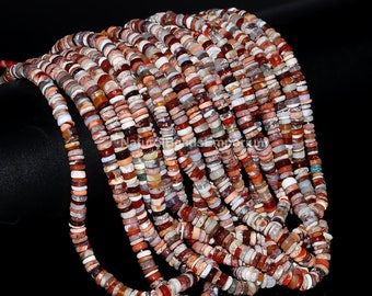 May include: A collection of multi-colored gemstone beads. The beads are small, flat, and disc-shaped, with a variety of colors including red, brown, white, and tan. The beads are strung together, creating a textured and visually appealing display.