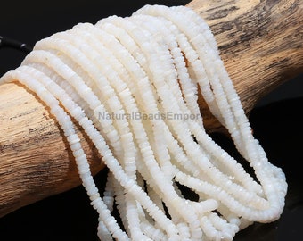May include: A strand of white opal beads, approximately 4mm in size, with a slightly irregular, faceted shape. The beads are strung on a clear thread and are displayed on a wooden surface.