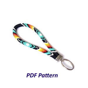 May include: A beaded key chain with a turquoise, orange, yellow, black, and white geometric pattern. The key chain has a silver key ring attached.