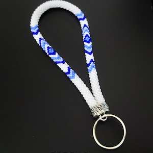 May include: White and blue beaded key chain with a silver key ring.  The beaded portion has a diamond pattern.  The text "PDF Pattern" is at the bottom of the image.