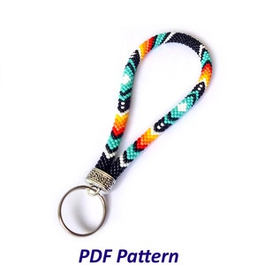 May include: A colorful beaded keychain with a black, white, turquoise, orange, and red pattern. The keychain has a silver ring and a silver clasp.