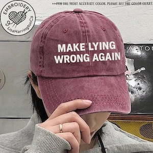 May include: A burgundy baseball cap with the text "MAKE LYING WRONG AGAIN" embroidered in white on the front.