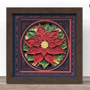 Op de afbeelding: Een ingelijst, gelaagd papieren kunstwerk met een poinsettia bloemontwerp. Het kunstwerk heeft een rode bloem met groene bladeren, een gouden centrum en een donkerbruine lijst. De achtergrond heeft blauwe en oranje accenten.
