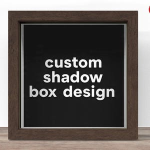 May include: A framed shadow box with a dark brown wooden frame. The background is black, with the words "custom shadow box design" in white, bold lettering. The Crafter Lobby logo is in the upper right corner.