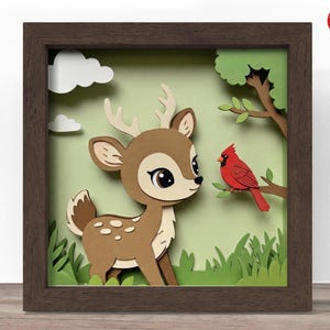 May include: A framed paper art piece depicting a deer and a red cardinal. The deer is brown with white spots and large eyes. The cardinal sits on a tree branch. The background is green with white clouds and grass.