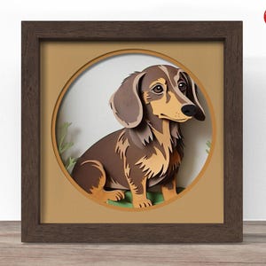 Puede incluir: Un marco cuadrado de madera marrón oscuro que contiene una obra de arte de papel en capas de un perro salchicha marrón y beige. El perro está colocado dentro de un recorte circular sobre un fondo beige, con pequeños acentos de follaje verde.