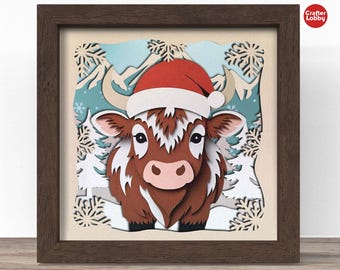 May include: A brown and white furry cow wearing a red Santa hat with white trim. The cow is standing in a snowy scene with white snowflakes and trees.