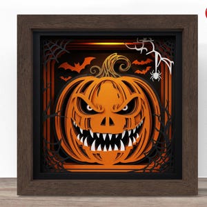 Puede incluir: Una obra de arte en papel en capas que presenta una calabaza naranja tallada con una cara enojada, murciélagos y telarañas. La obra de arte está enmarcada en un marco de madera marrón oscuro, perfecta para la decoración de Halloween.