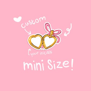 Puede incluir: Un relicario dorado en forma de corazón con un lazo rosa, etiquetado como "custom" y "your initials" sobre un fondo rosa. También está presente el texto "mini Size!". El relicario está abierto, revelando dos espacios en forma de corazón en blanco.