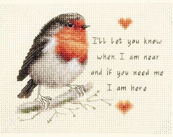May include: Cross-stitch artwork of a robin perched on a branch. The bird has a red breast, gray and black wings, and is set against a cream-colored background. Text reads, "I'll let you know when I am near and if you need me I am here."
