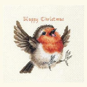 May include: Cross-stitch Christmas card depicting a robin with its wings spread and beak open. The bird has a red breast and brown wings, set against a cream background. The words "Happy Christmas" are stitched above the bird.