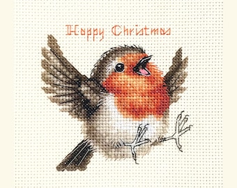 May include: Cross-stitch Christmas card featuring a robin with outstretched wings and open beak. The bird has a red breast, brown wings, and is set against a cream background. The words "Happy Christmas" are stitched above the bird.