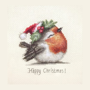 May include: A cross-stitch embroidery featuring a round robin bird with a red breast, wearing a red Santa hat adorned with green holly leaves and red berries. The text "Happy Christmas!" is stitched in dark grey below the bird on white fabric.
