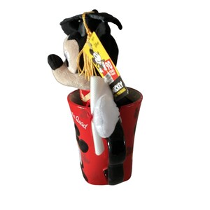 May include: A red ceramic mug with a black handle and a Mickey Mouse design. The mug says "It's Grad" and has black polka dots. A plush Mickey Mouse wearing a graduation cap and gown is sitting inside the mug. The plush Mickey Mouse has a yellow tag that says "Mickey 90 Years of Magic".
