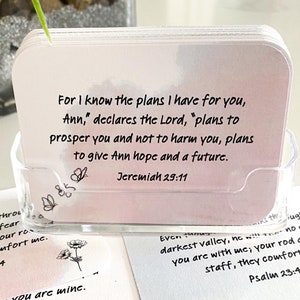 Peut inclure: Un ensemble de cartes inspirantes avec des versets bibliques imprimés dessus. Les cartes présentent un fond aquarelle et un motif de papillon. Le texte sur les cartes comprend des versets de Jérémie, des Psaumes, d'Isaïe et de Corinthiens.