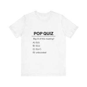 Op de afbeelding: Wit t-shirt met de tekst "POP QUIZ" in zwart, gevolgd door een vraag over Big-O notatie en meerkeuzeantwoorden. Het shirt is gemaakt van een zacht materiaal.