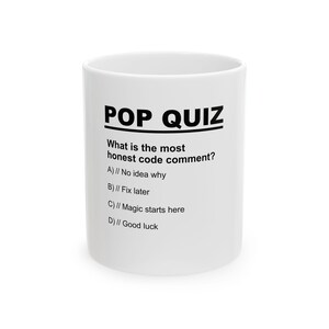 May include: White ceramic mug featuring the text "POP QUIZ" in bold black letters. The mug poses a question about honest code comments with multiple-choice answers. A humorous gift for software developers.