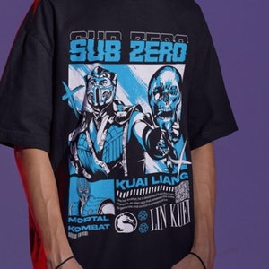 May include: Black t-shirt featuring a graphic print of Sub-Zero from Mortal Kombat. The graphic includes Sub-Zero's face and the text "Sub-Zero", "Kua Liang", "Mortal Kombat", and "Lin Kuei".