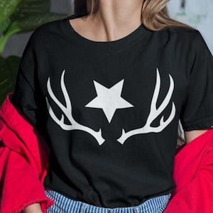 Op de afbeelding: Zwart T-shirt met een witte ster en geweimotief.